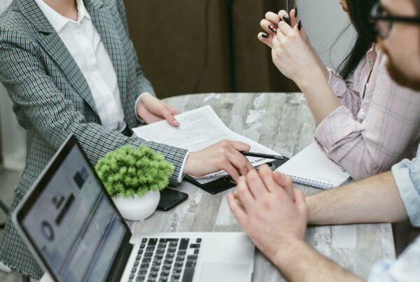 Financial professionals in a strategy meeting reviewing documents and data on laptops, symbolizing institutional investment planning for growth