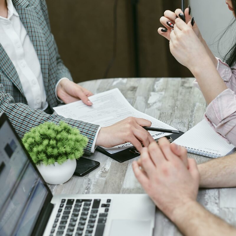 Financial professionals in a strategy meeting reviewing documents and data on laptops, symbolizing institutional investment planning for growth