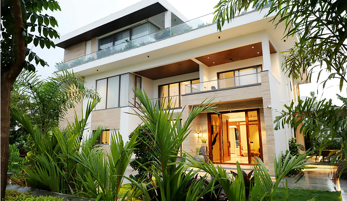 Modern luxury home surrounded by greenery, representing the success and lifestyle made possible through effective wealth management
