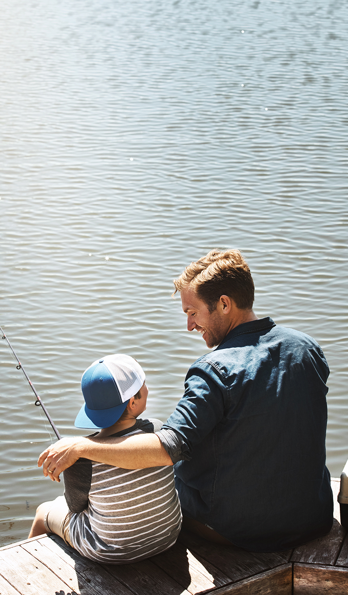 Father and son fishing by a calm lake, symbolizing trust, legacy, and the personalized guidance offered by Point2 Capital Partners